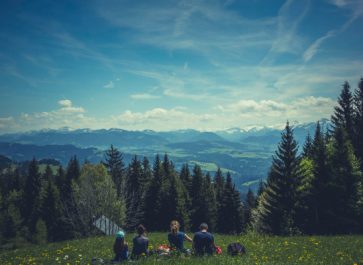 Family sitting in the grass on a mountain top